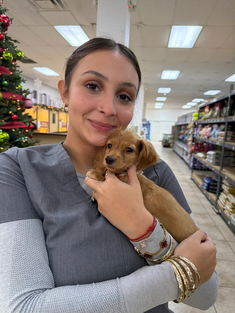 A woman holding a golden-colored puppy at Petland Fort Myers