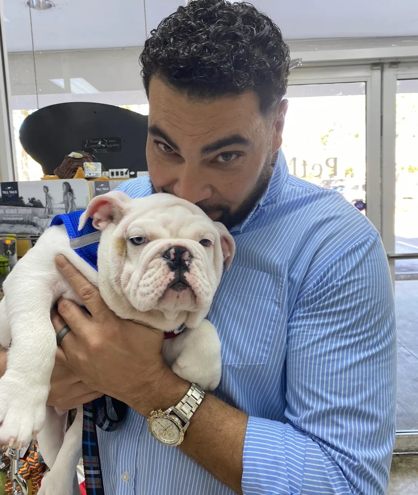 A man holding a white bulldog puppy at Petland Fort Myers
